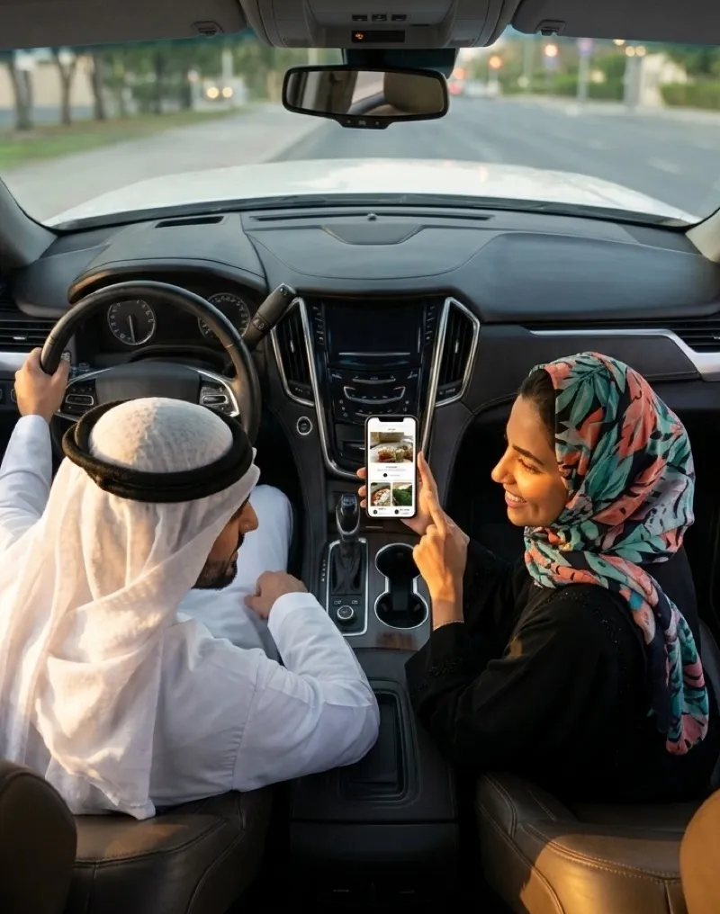 عميلان في السيارة يتصفحان المنيو على الجوال قبل الوصول